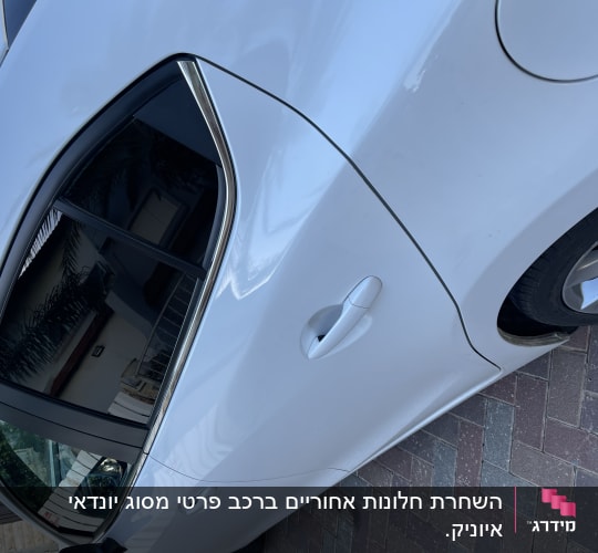 מכונית לבנה עם חלון כהה ומסגרת כרום